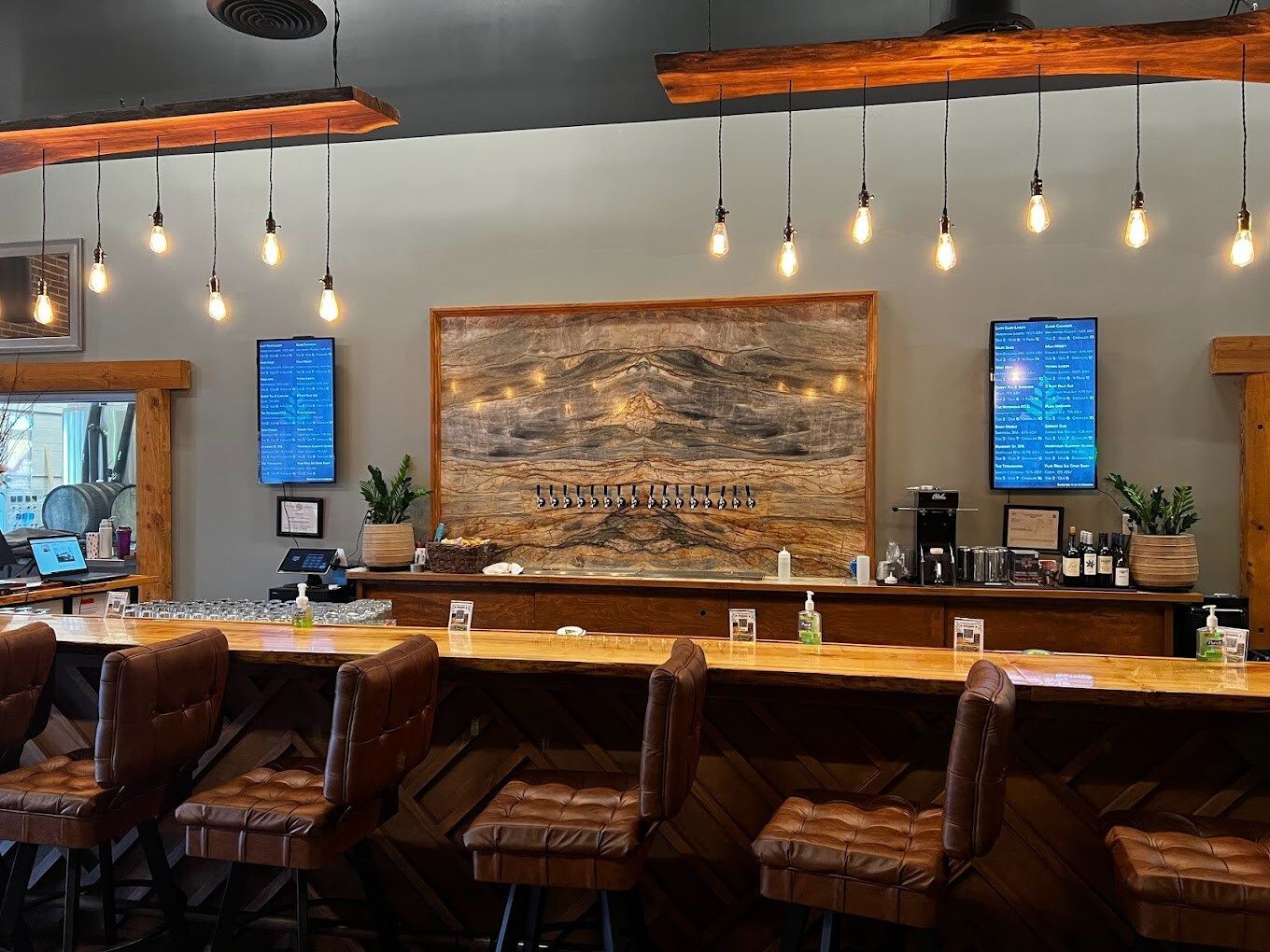 A restaurant with a long wooden bar and chairs.