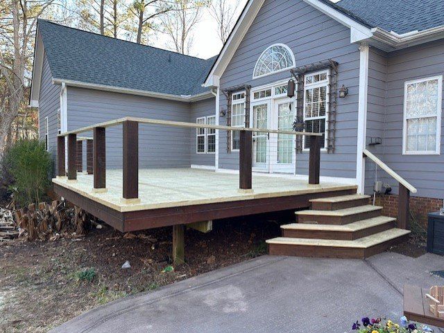 A house with a wooden deck and stairs in front of it.