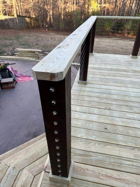 A close up of a wooden deck with a metal railing.