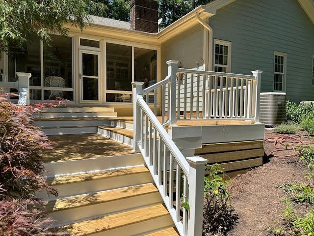 A house with a screened in porch and stairs leading to it.