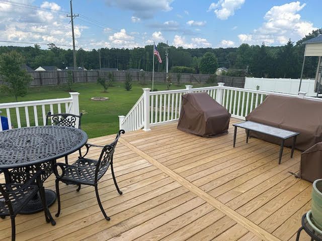 A wooden deck with a table and chairs on it.