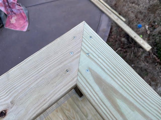 A close up of a piece of wood with screws in it.