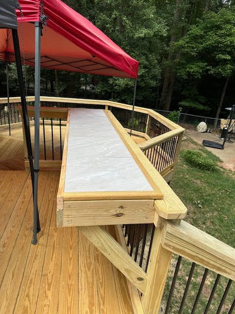 A wooden deck with a red tent on top of it.
