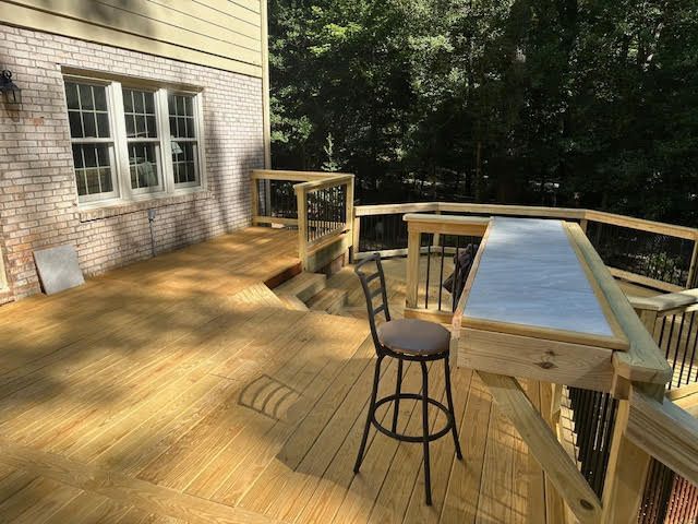 A wooden deck with a table and chairs on it.