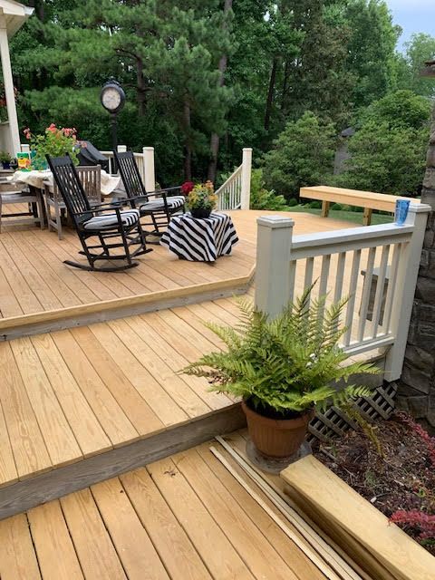 A wooden deck with rocking chairs and a table