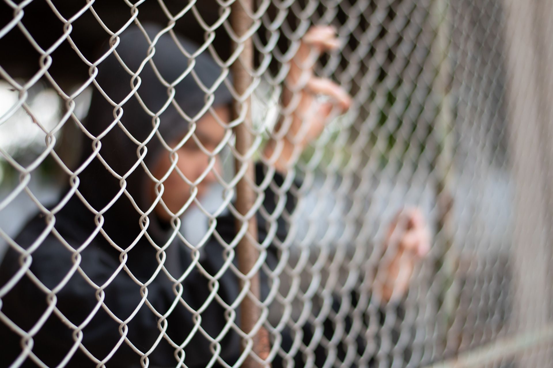 Detention of preteens inside the metal fence and wall because of their bad behavior and habits, freedom and human rights concept