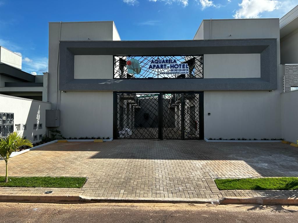 Prédio cinza com portão de ferro preto e placa com os dizeres