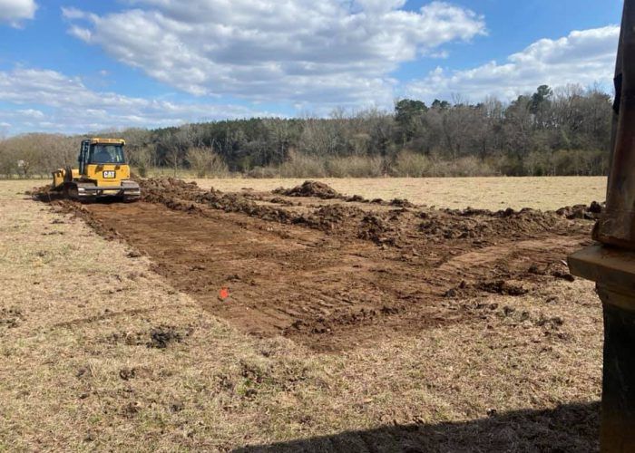 A bulldozer is moving dirt in a field.