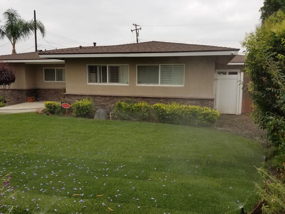 A house with a sprinkler in front of it