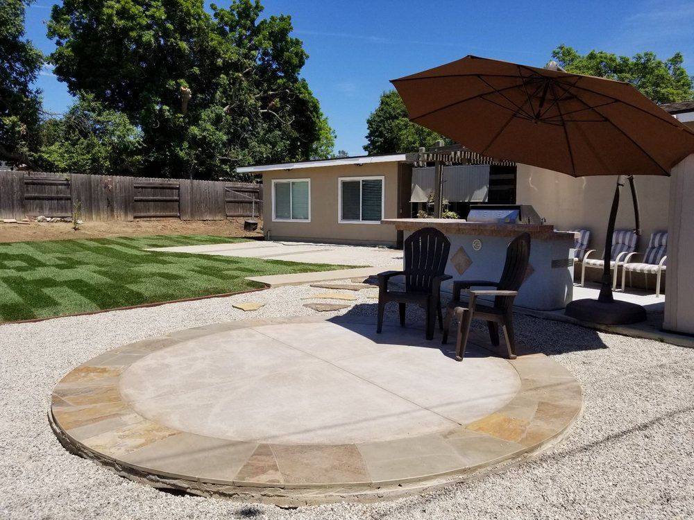 A patio with a table and chairs and an umbrella