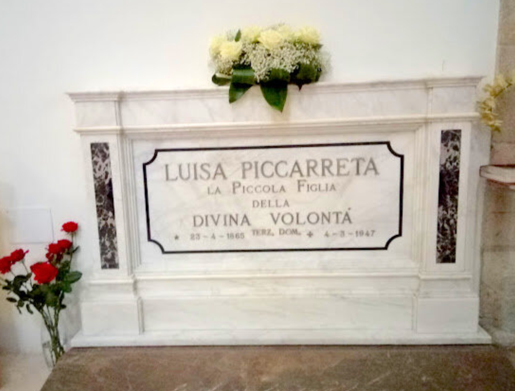 A gravestone for luisa piccareta is surrounded by flowers