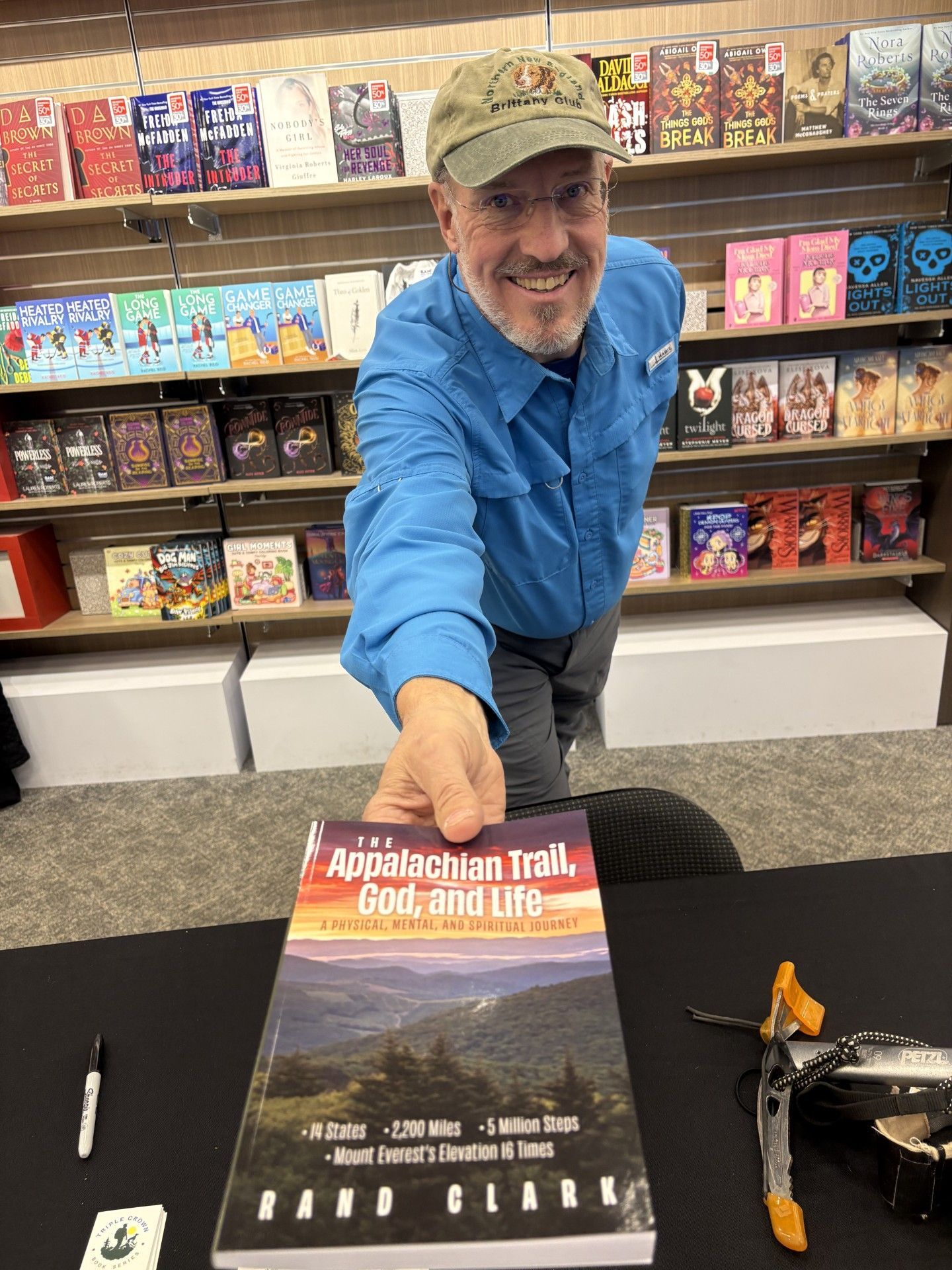 Man holding out a book titled 