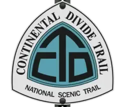 Continental Divide Trail marker, white triangle with blue and black CDT logo, on a black post.