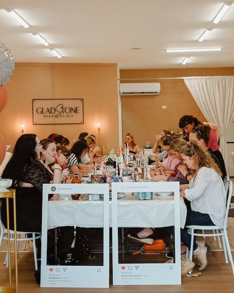 A Group of People Are Sitting at Tables in A Room — Gladstone Beauty Clinic In Gladstone Central QLD