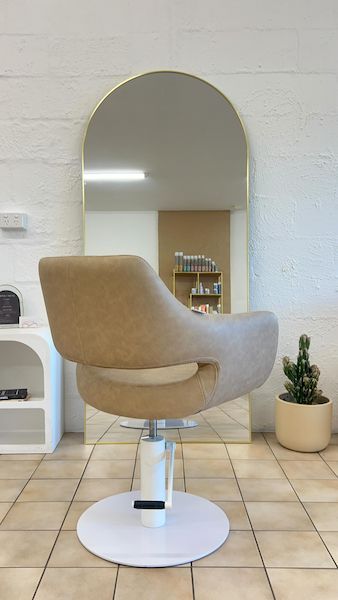 A Chair Is Sitting in Front of A Large Mirror in A Salon — Gladstone Beauty Clinic In Gladstone Central QLD