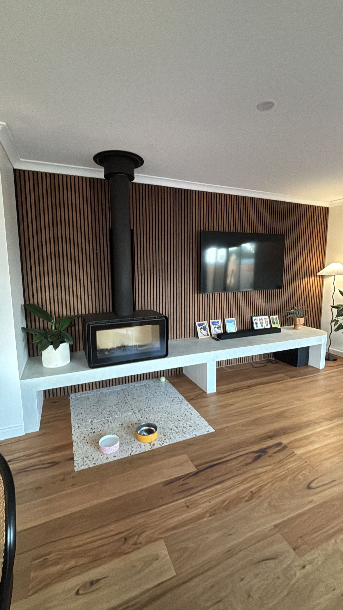 A living room with hardwood floors , a fireplace and a flat screen tv.