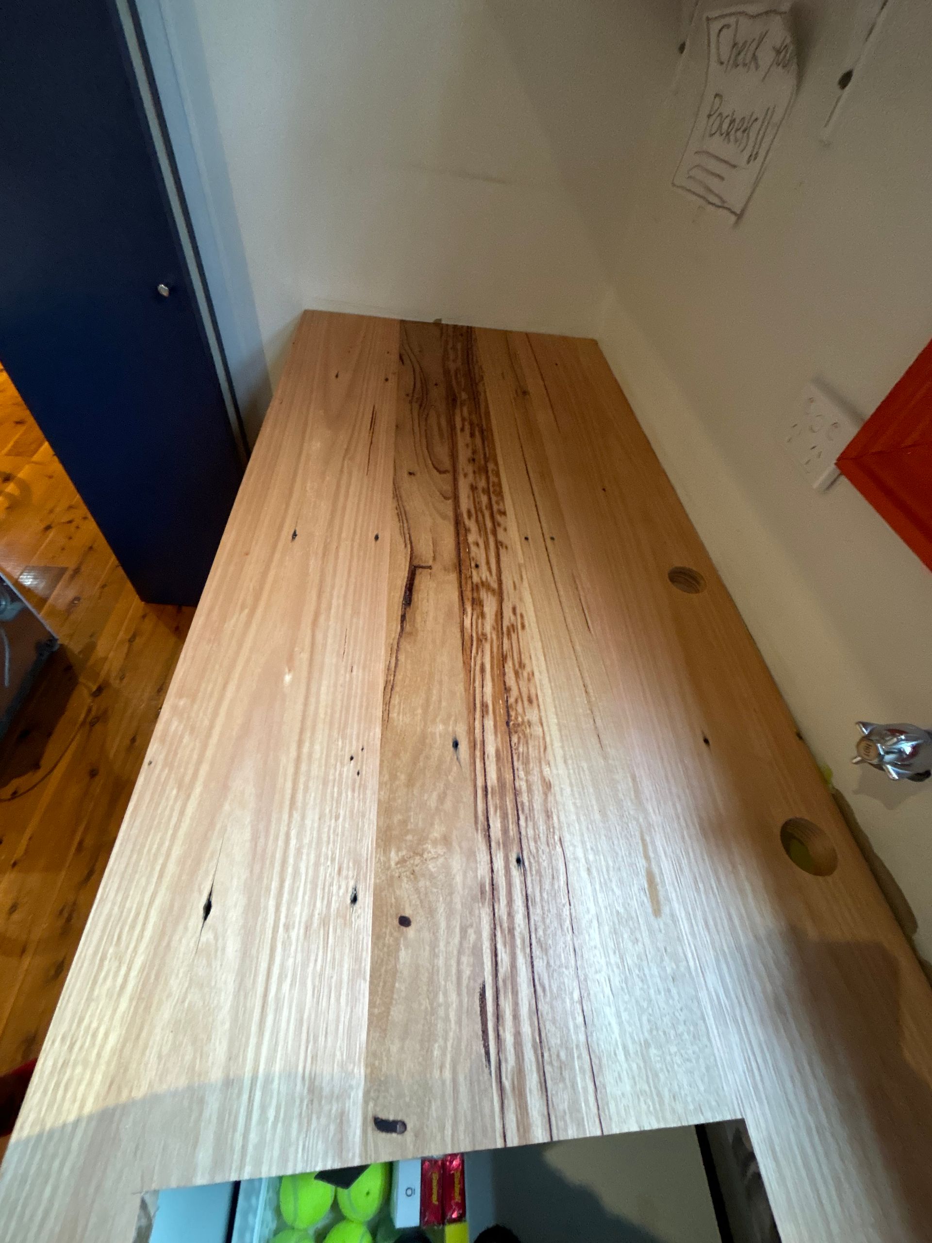 A wooden table is sitting in a room next to a wall.