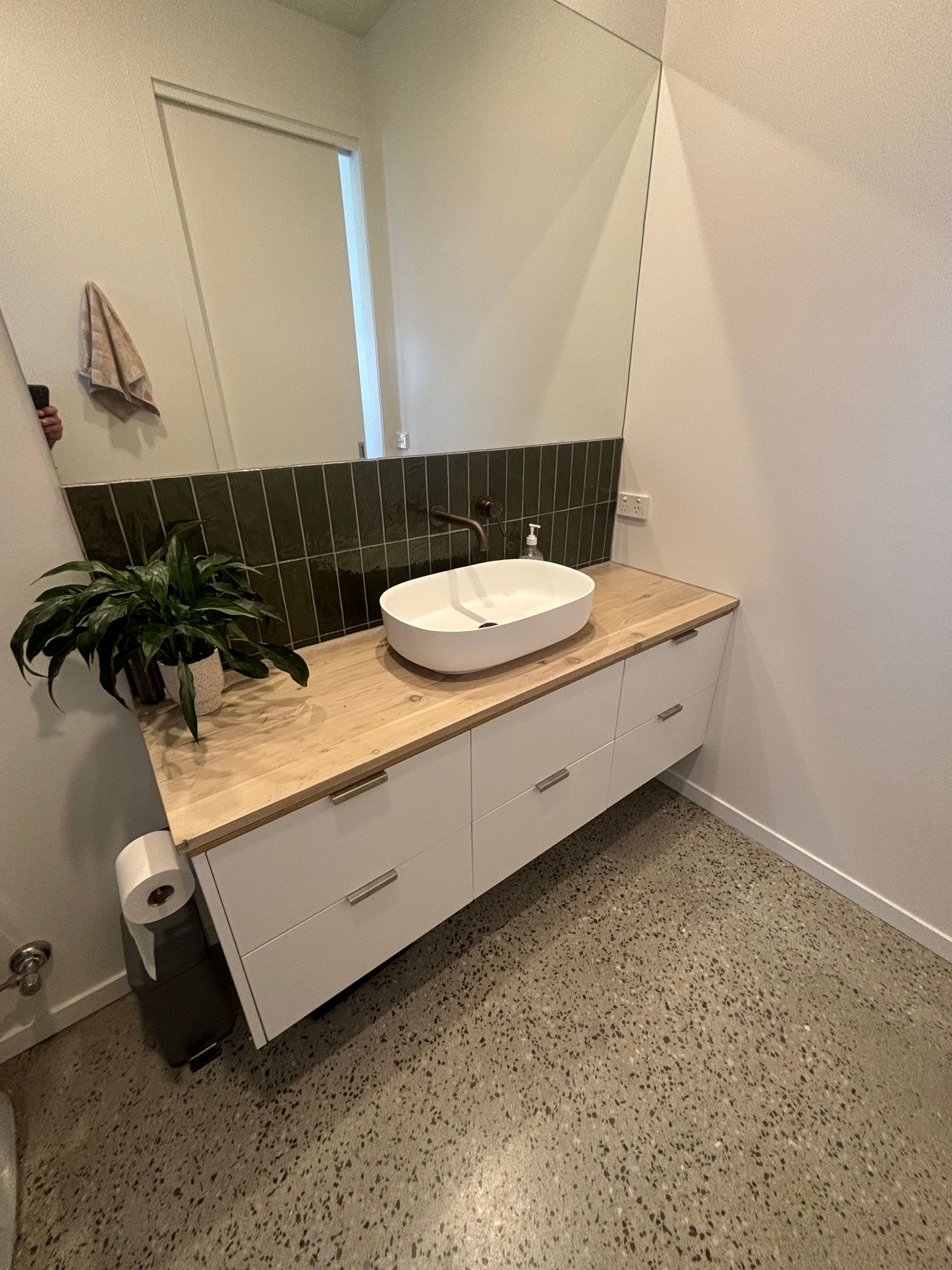 A bathroom with a sink and a large mirror.