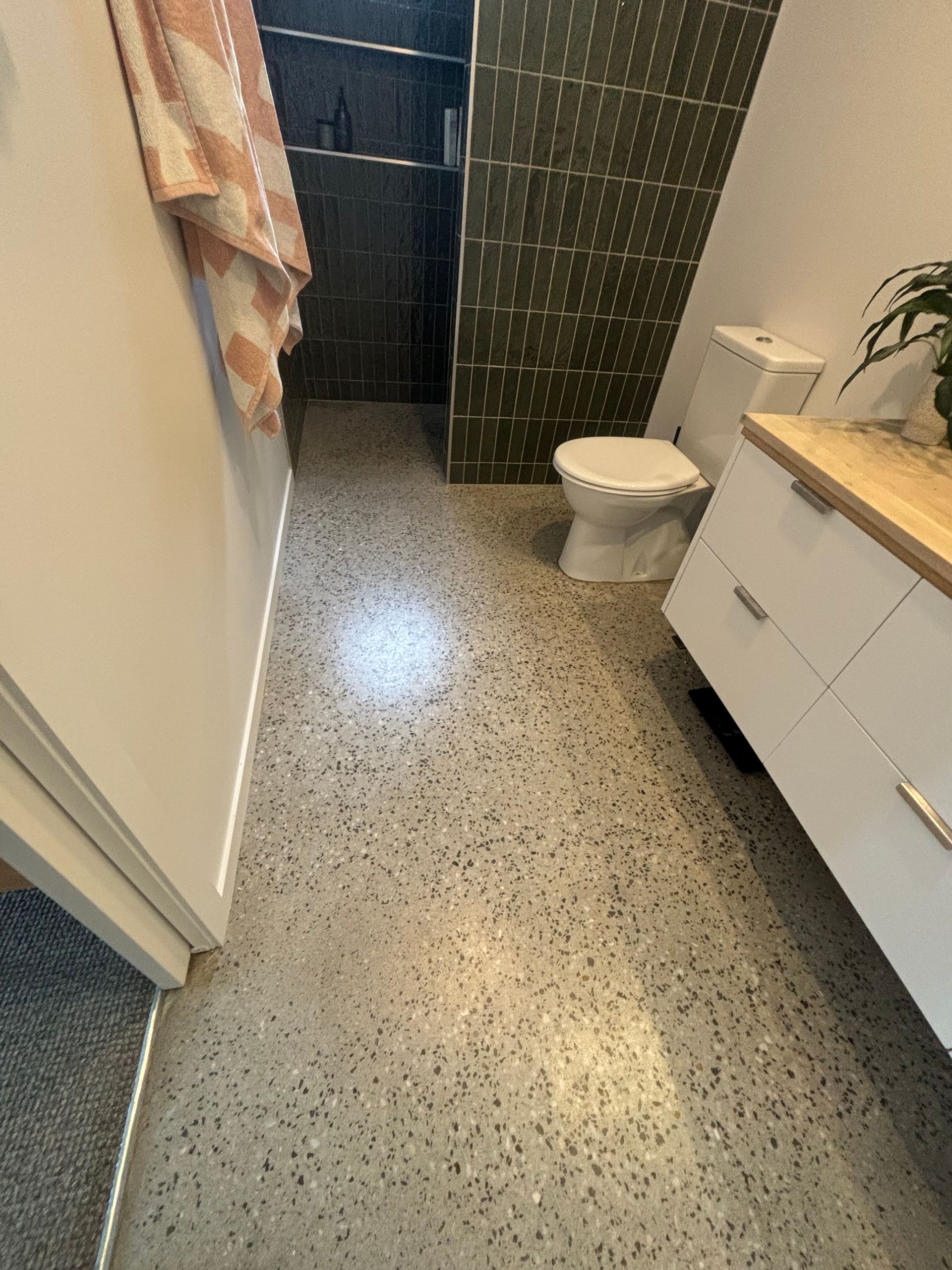 A bathroom with a toilet , sink and shower.