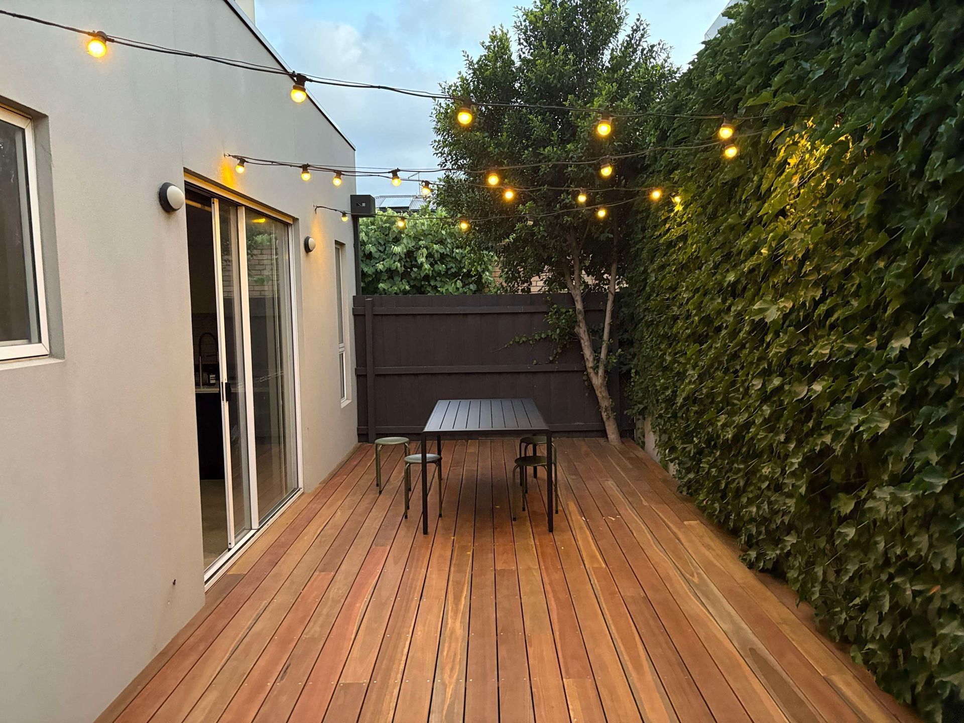 There is a wooden deck with a table and chairs on it.