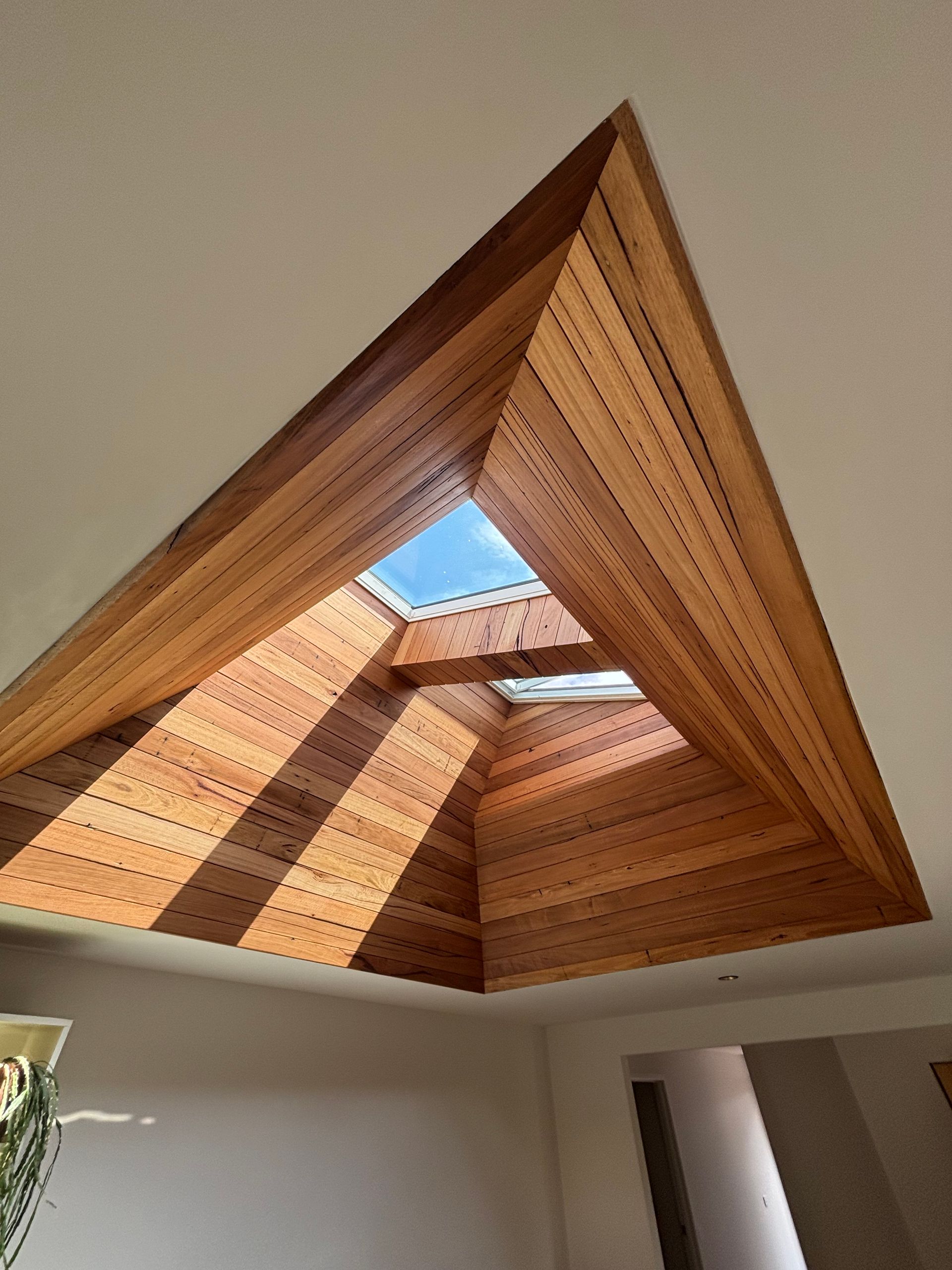 Looking up at a wooden ceiling with a skylight