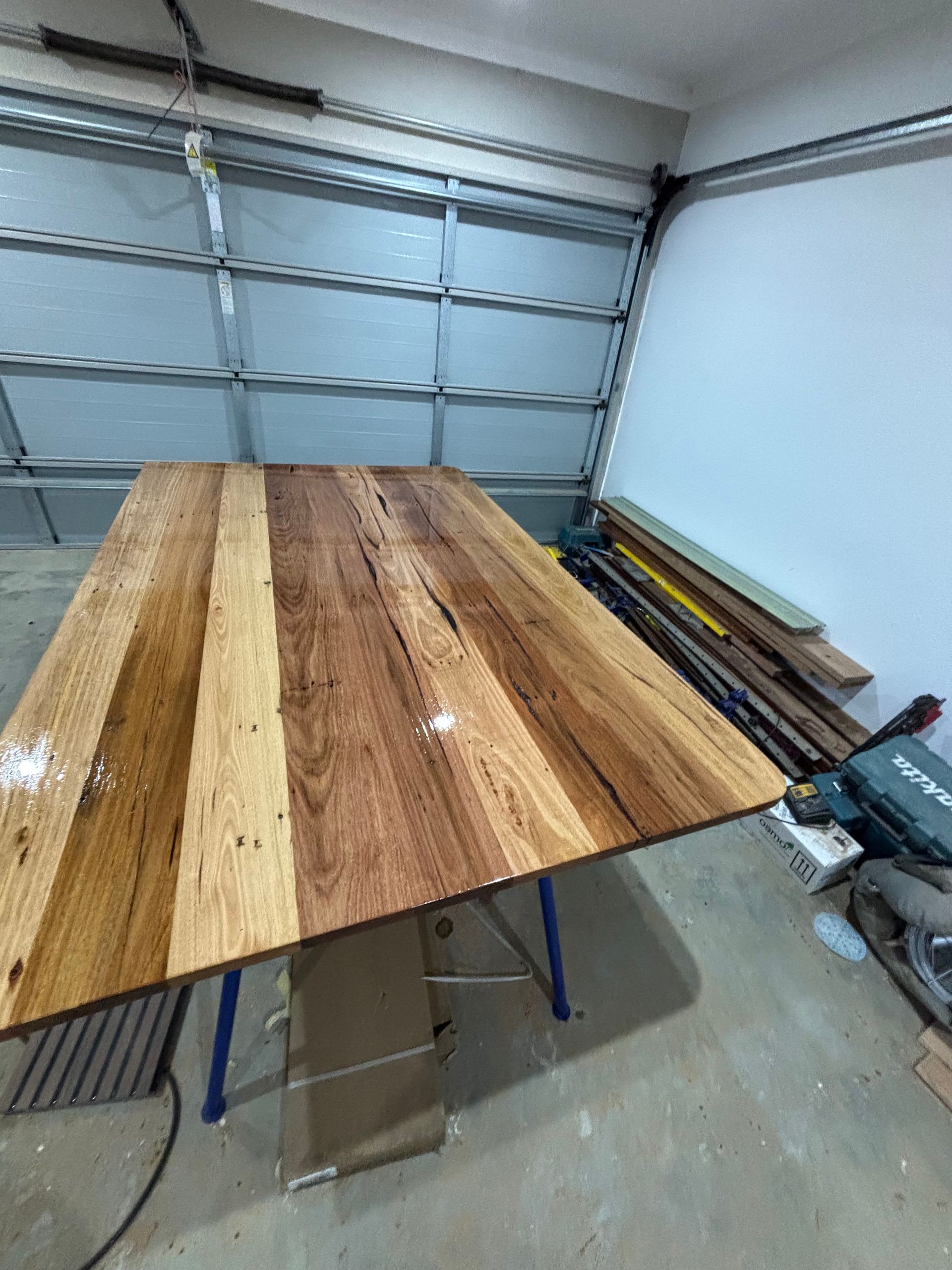 A wooden table is sitting in a garage next to a garage door.