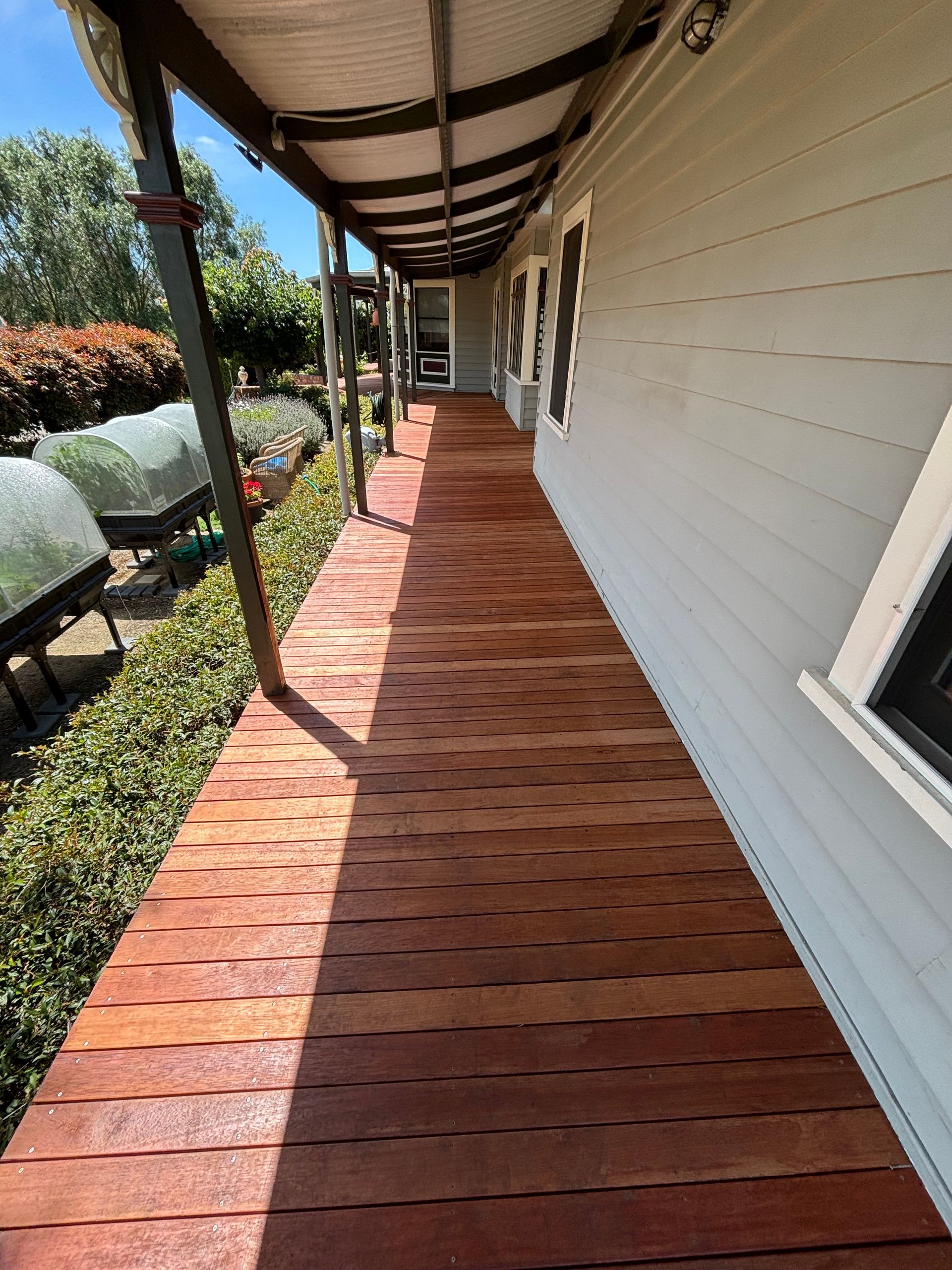 A long wooden walkway leading to a white house.