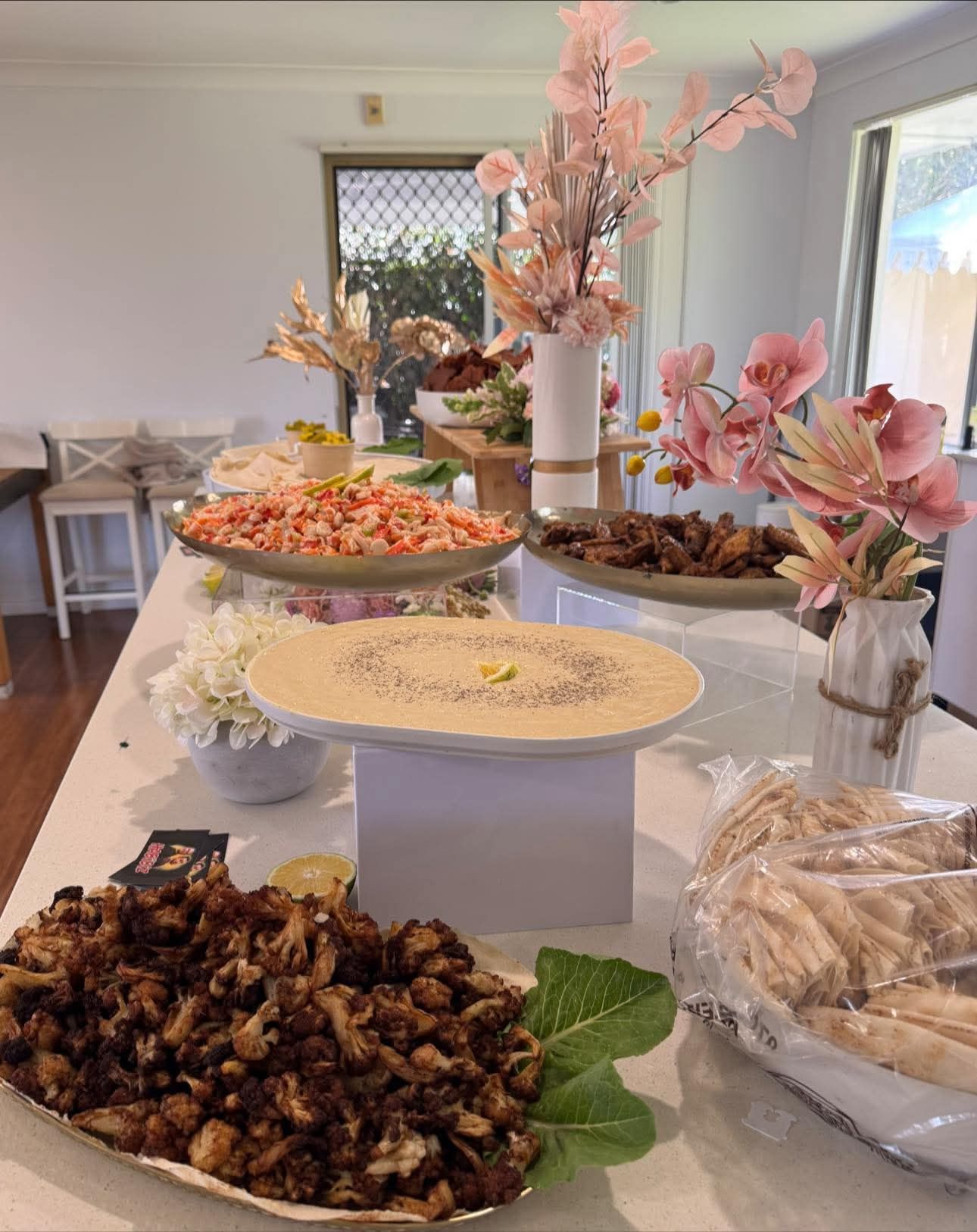 A buffet table laden with food and floral arrangements — The Habibiz Catering in Newcastle, NSW