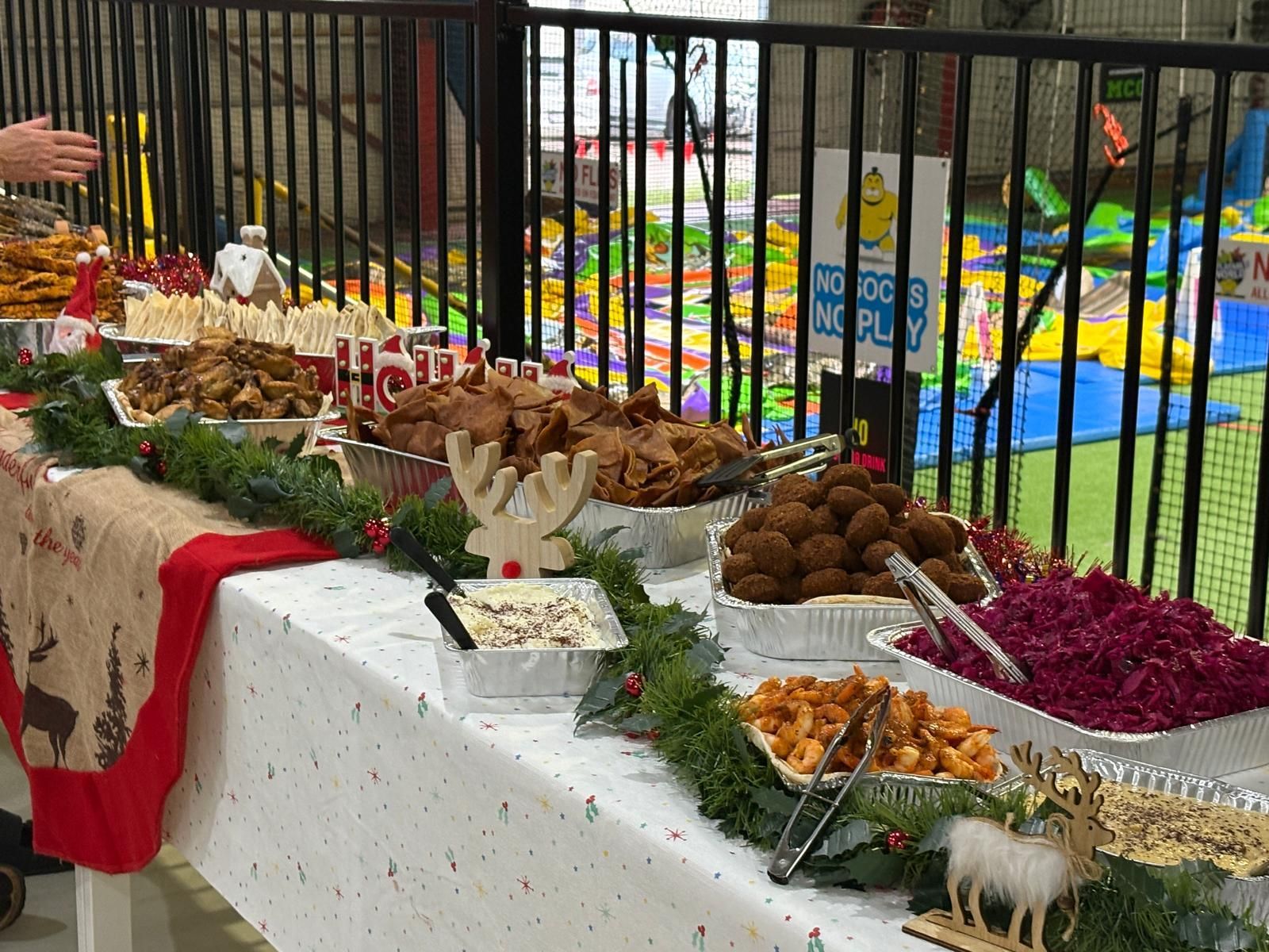 A food buffet with various dishes, decorated with garlands. Indoor setting, possibly a party or event. — The Habibiz Catering In Wingham, NSW