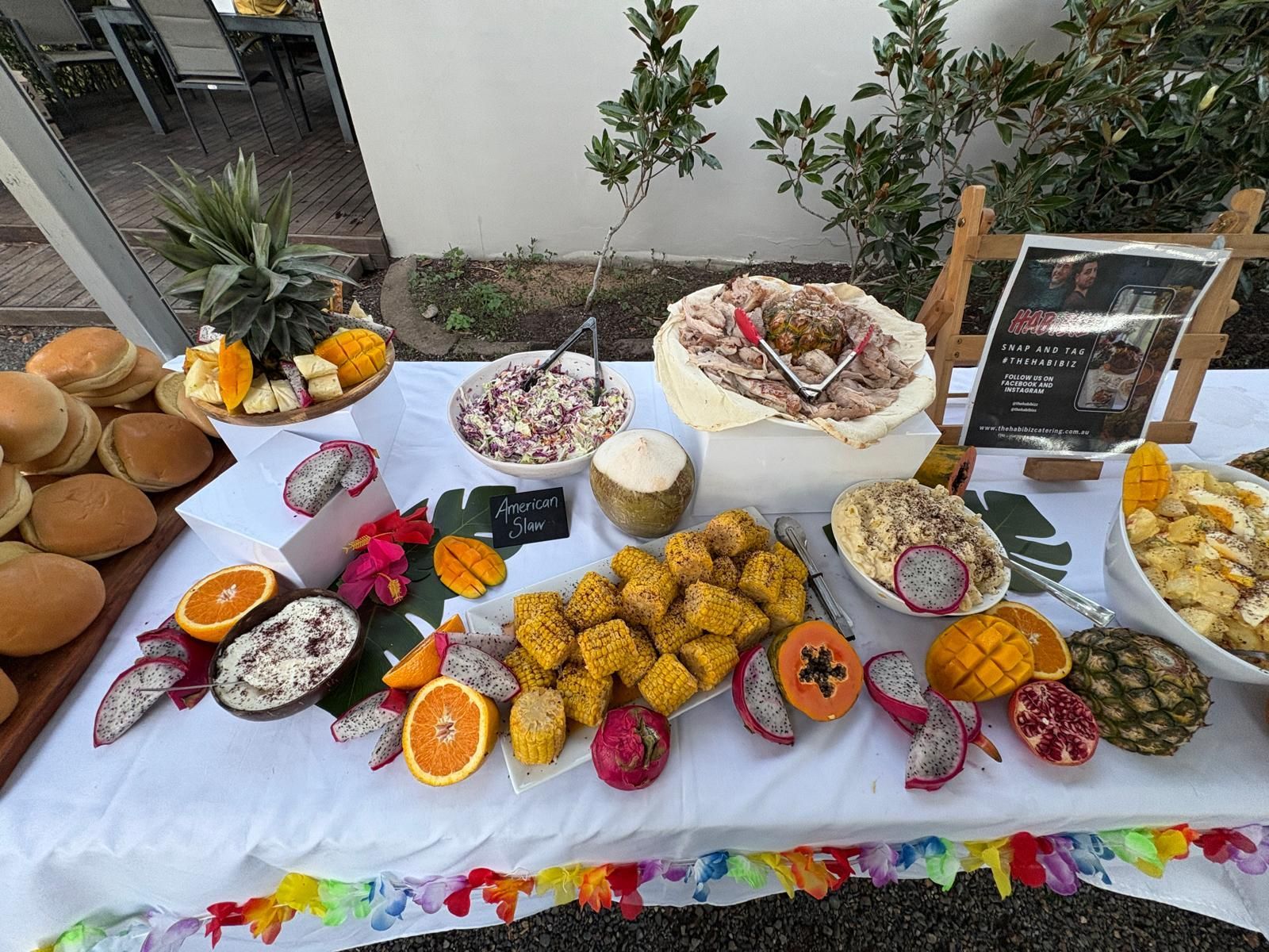 A tropical buffet table with various fruits, salads, and buns. — The Habibiz Catering In Wingham, NSW