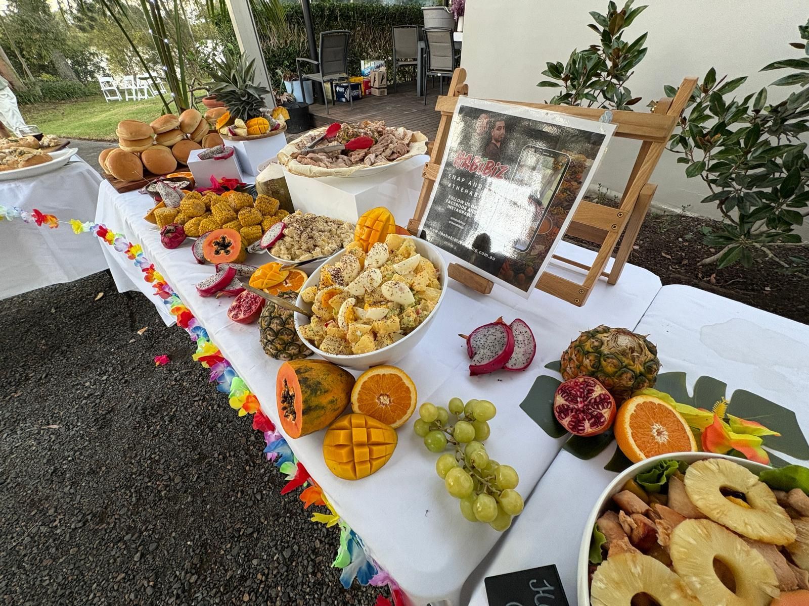 Buffet table with tropical food, including fruit, pineapple, and shrimp, set outdoors. — The Habibiz Catering In Wingham, NSW