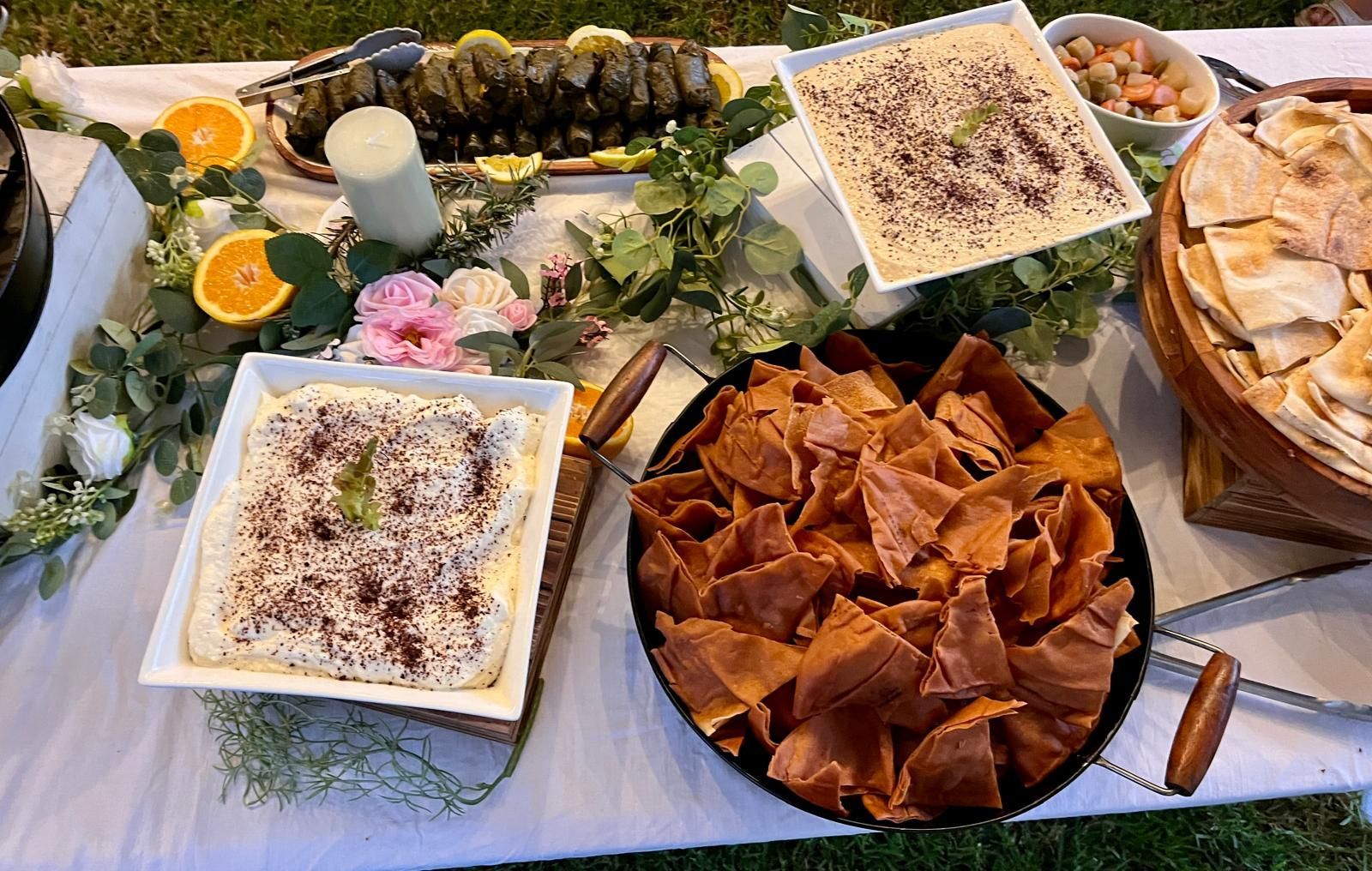 Buffet table with hummus, pita chips, stuffed grape leaves, olives, and bread. — The Habibiz Catering In Wingham, NSW
