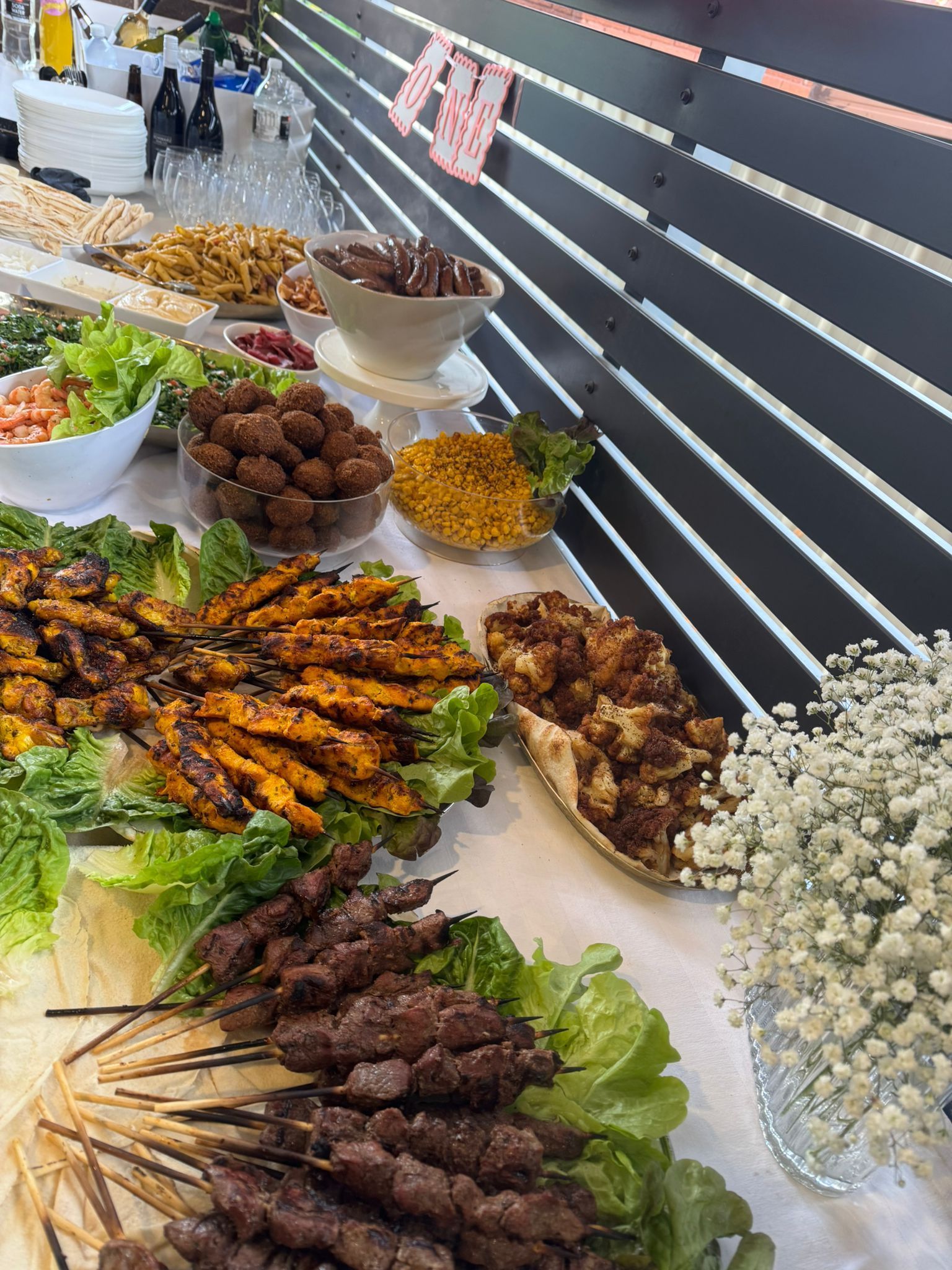 Buffet table with various foods: skewers, chicken, meatballs, salad, and nuts — The Habibiz Catering in Newcastle, NSW