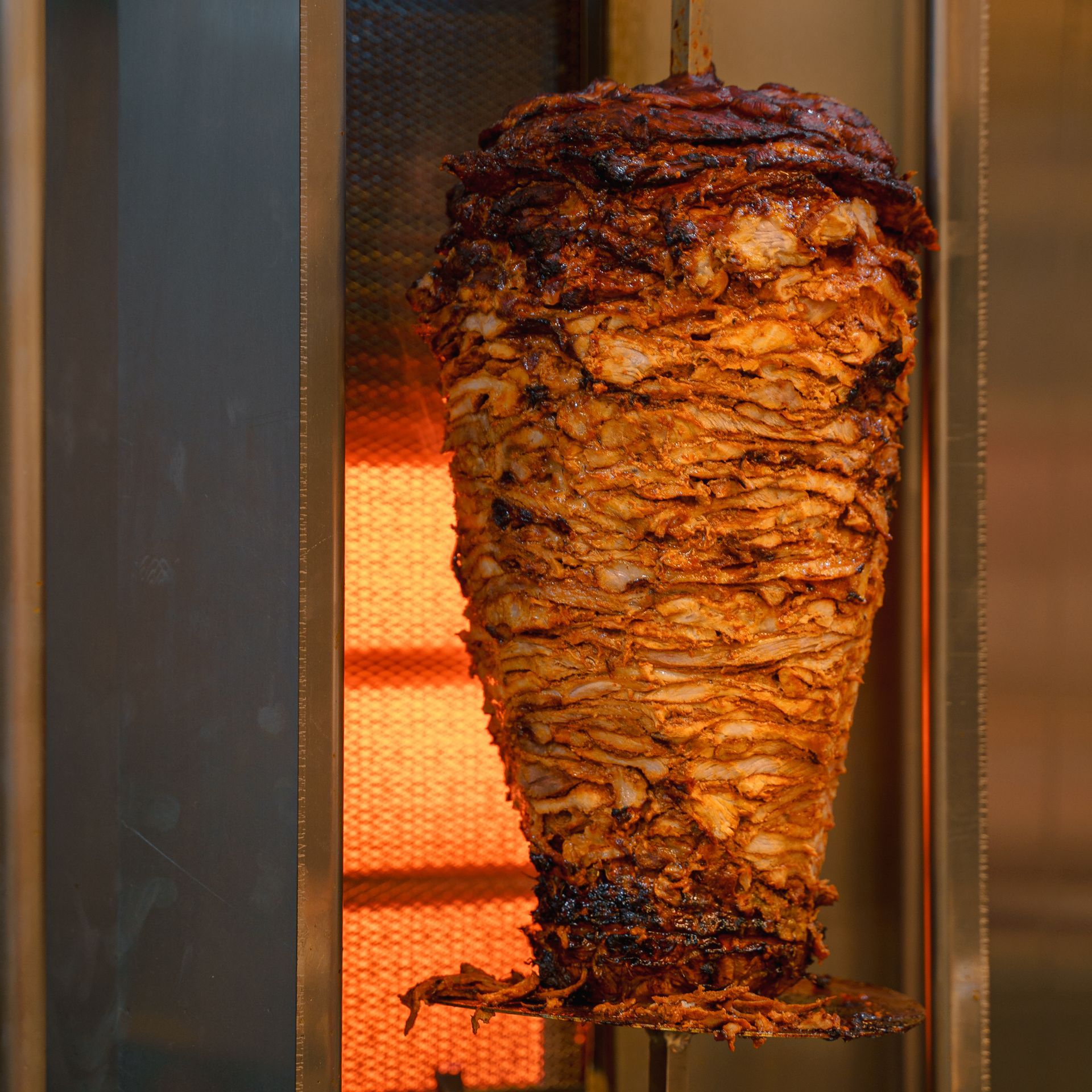 A large piece of meat is being cooked on a grill.