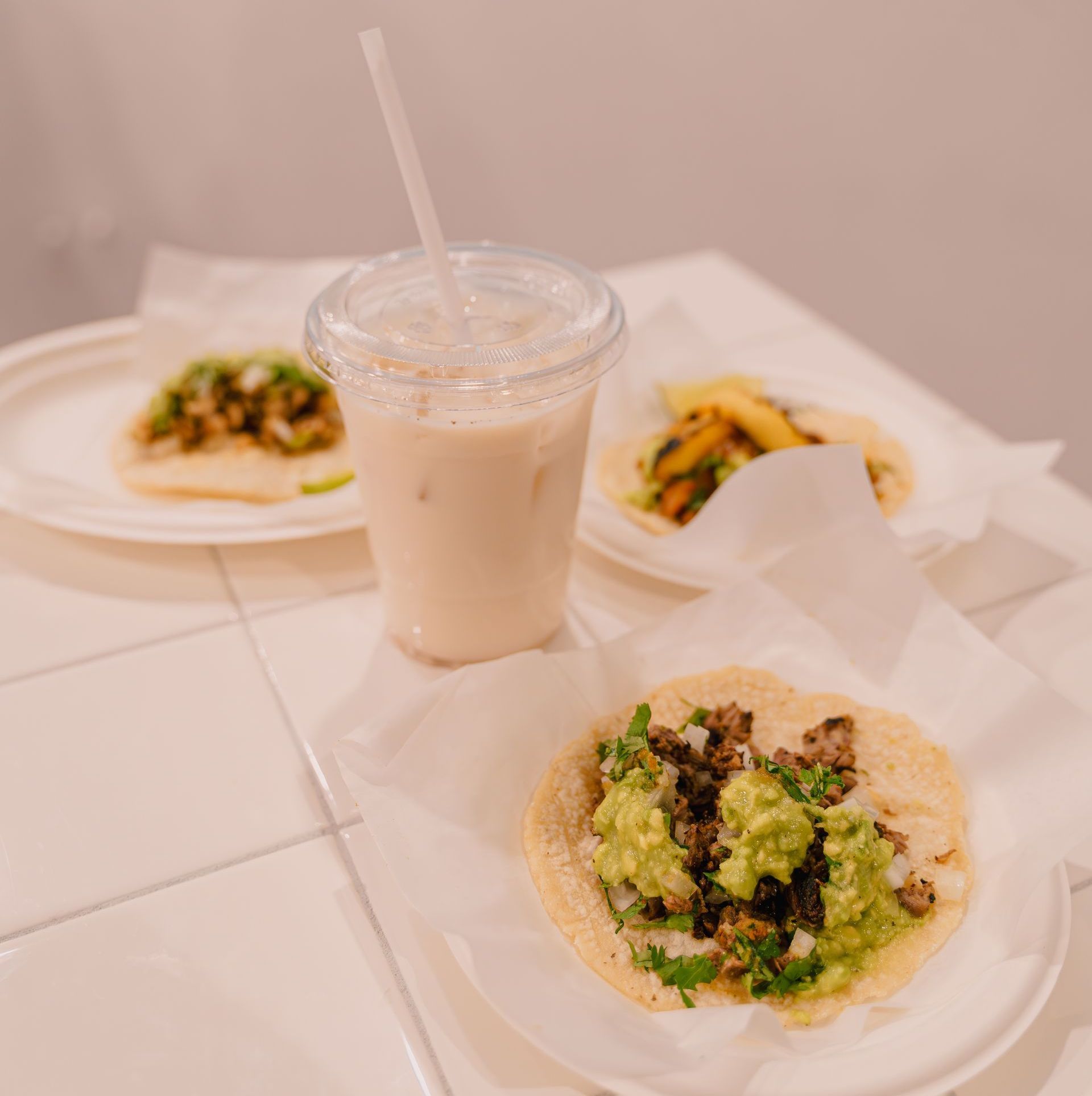 A table topped with plates of food and a drink.