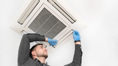Technician Checking Ceiling AC — Denver, CO — Pace & Sons Mechanical