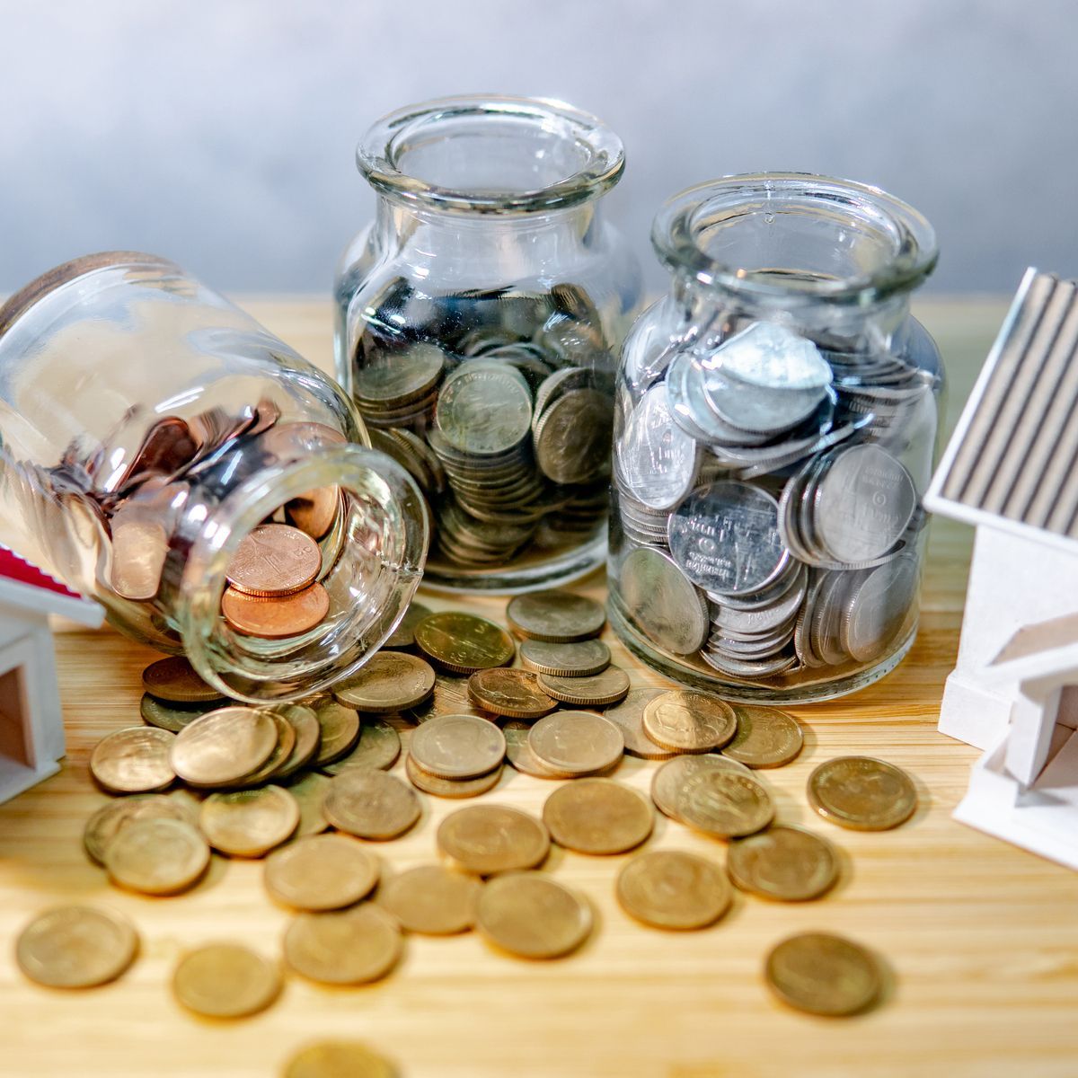 Image of coin jars representing savings and investments in real estate - start building wealth today