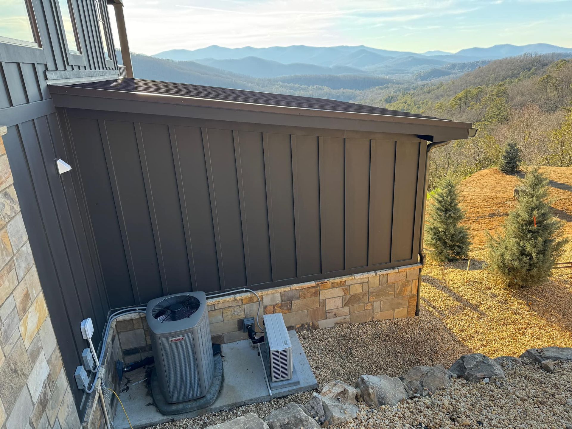 A house with a view of the mountains and a air conditioner on the side of it.