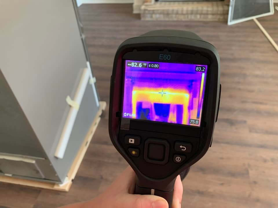 A person is holding a thermal camera in their hand.