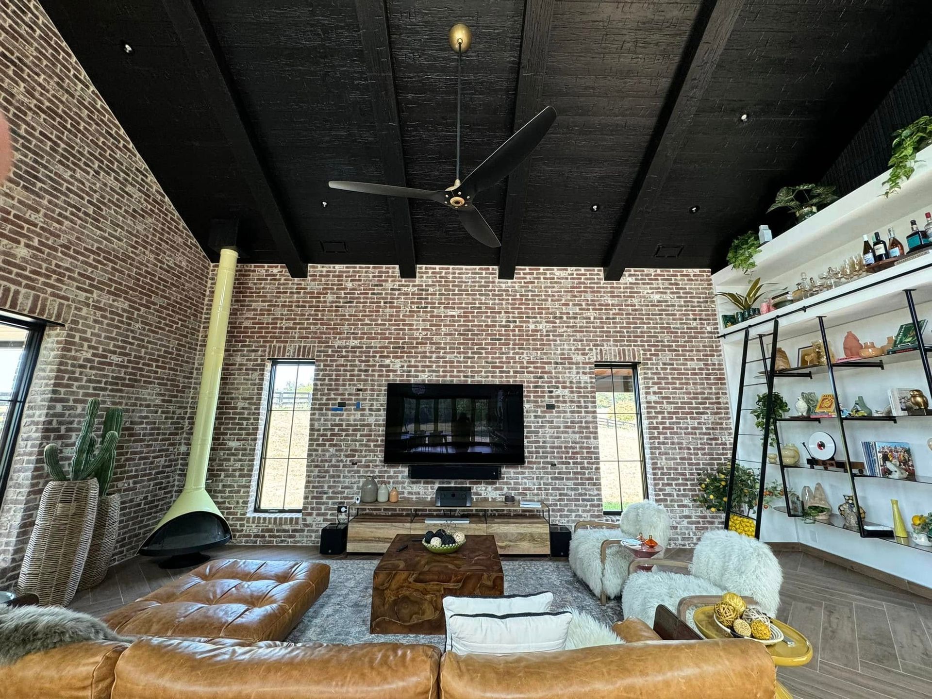 A living room with a brick wall and a flat screen tv