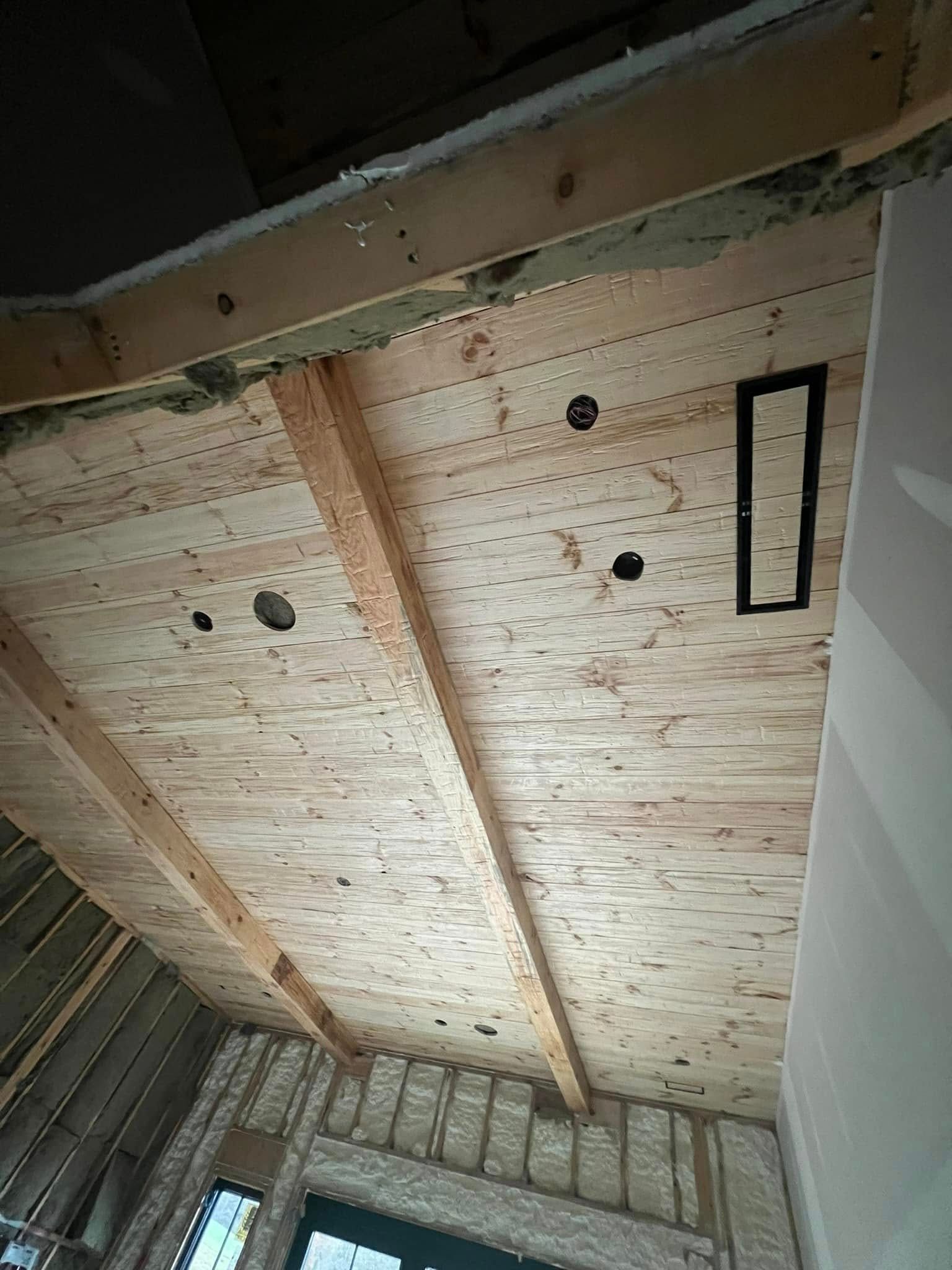 A wooden ceiling with holes in it is being built in a house.