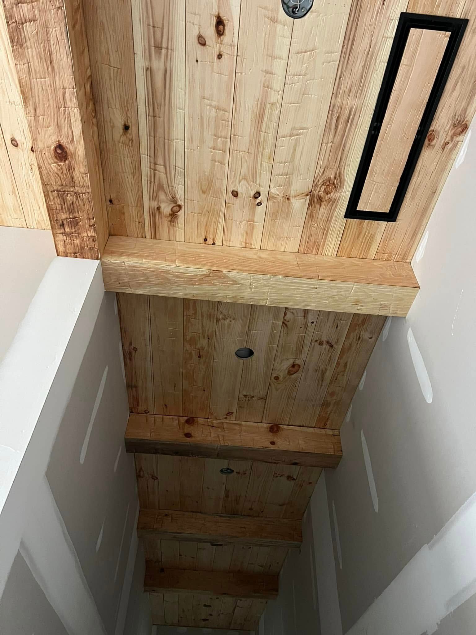 A wooden ceiling with beams in a hallway.