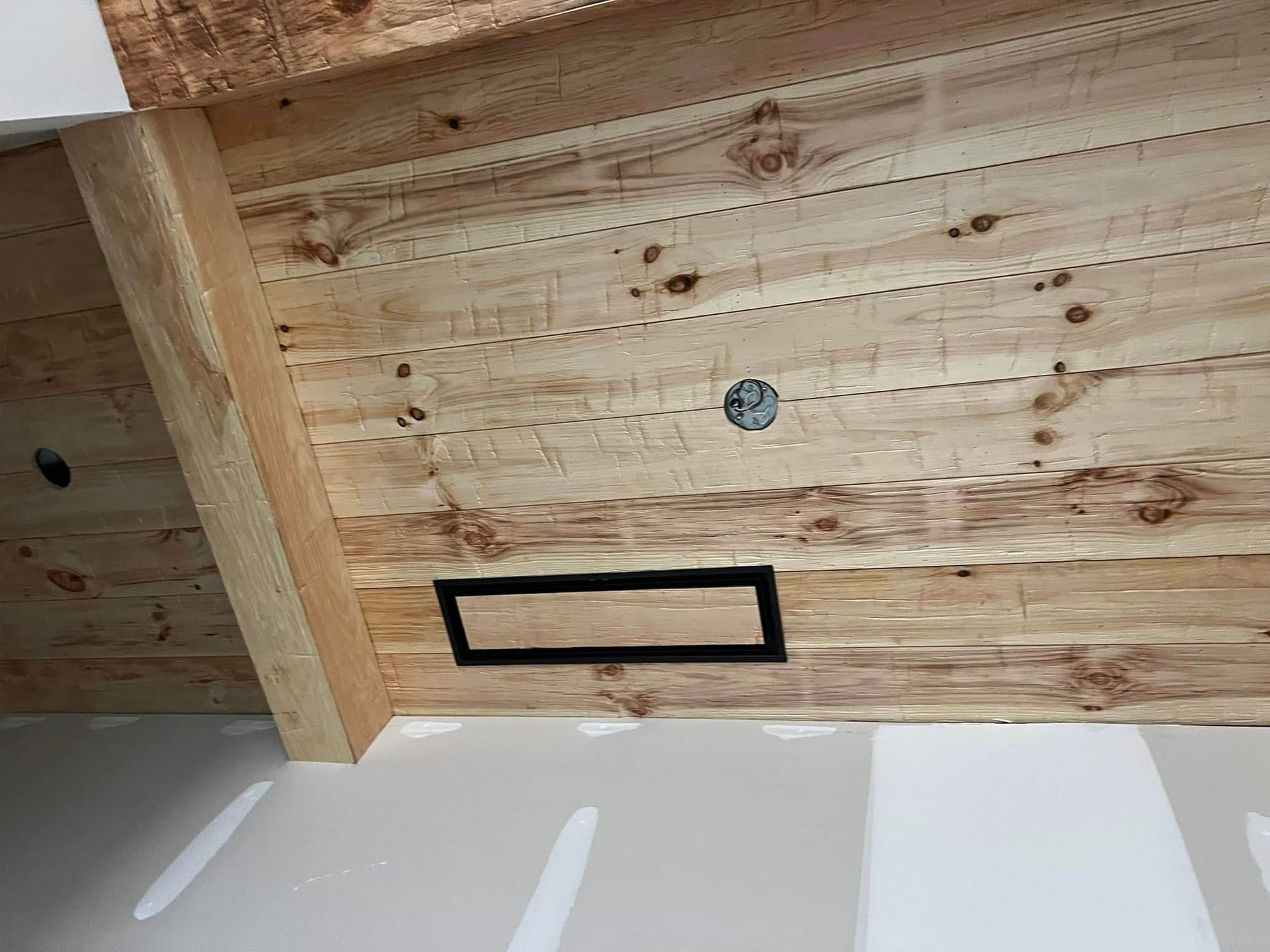A wooden wall with a black frame on it is being built.