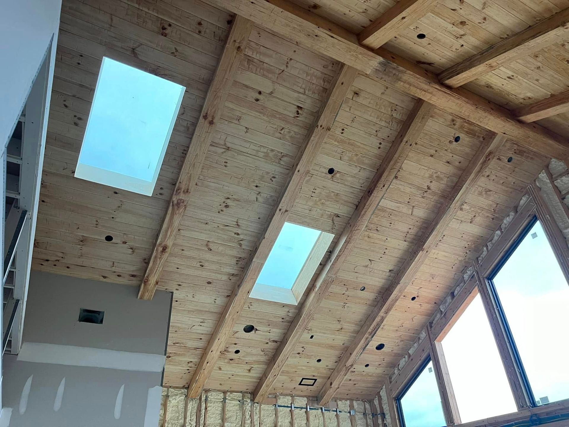 A wooden ceiling with two skylights and a lot of windows