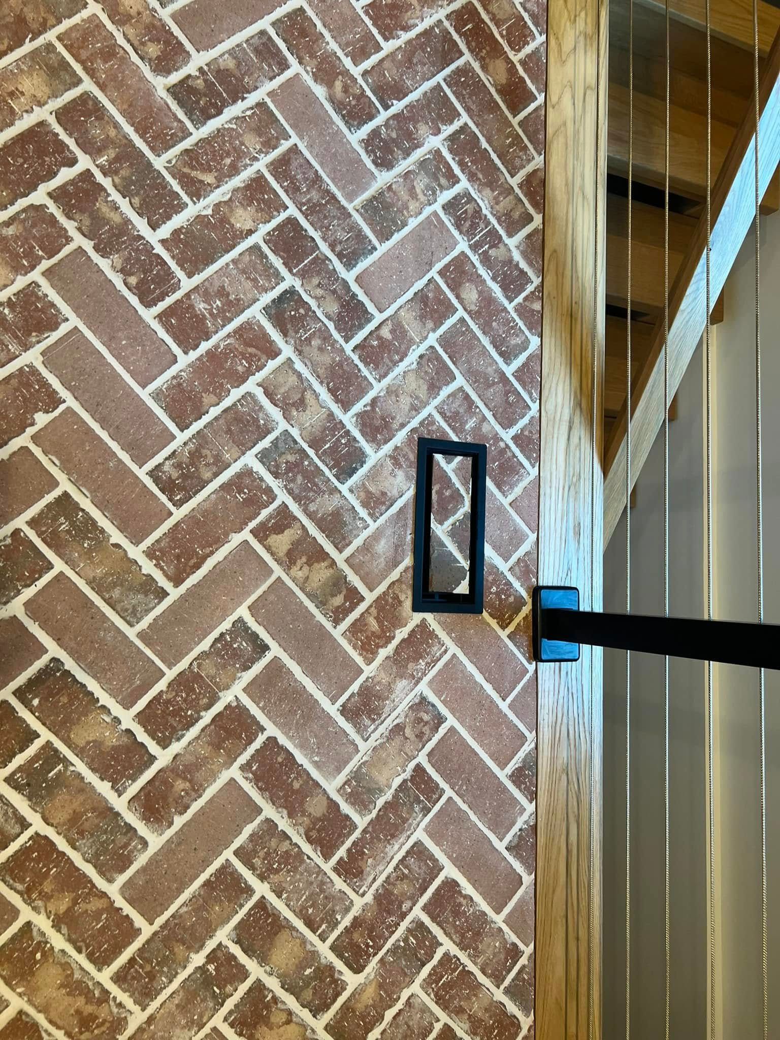 A close up of a brick wall with a herringbone pattern.