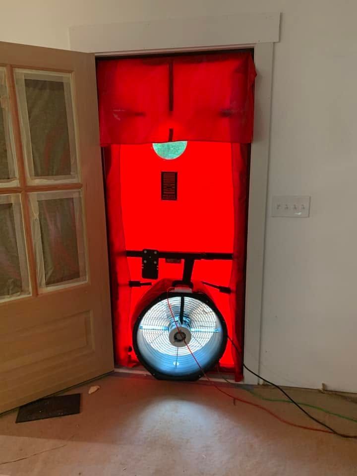 A red door with a fan coming out of it.