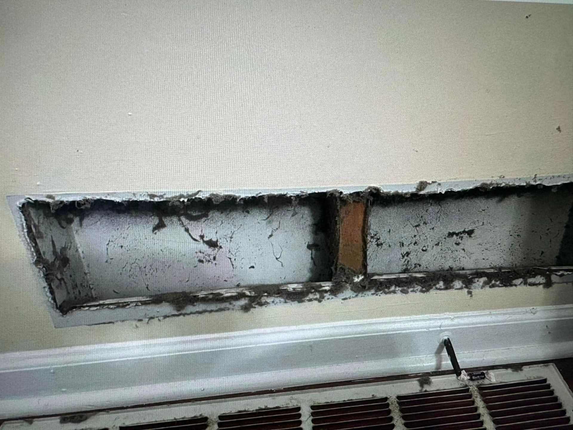 A hole in a wall with a fan coming out of it.