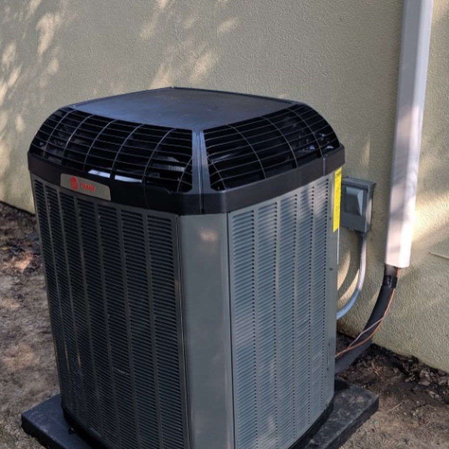 A large gray box with a smoke stack on the side of a building