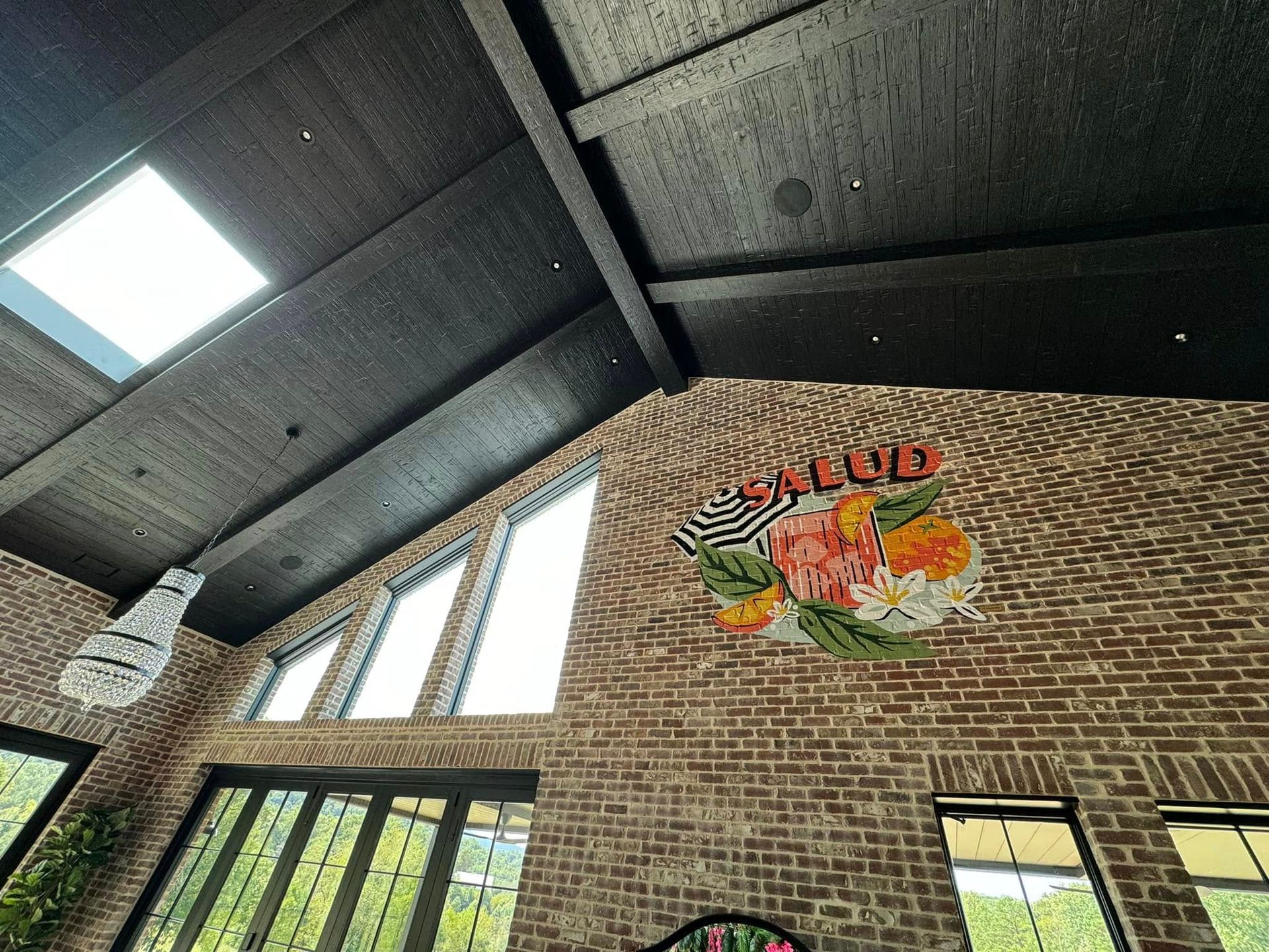 A large room with a vaulted ceiling and a brick wall.