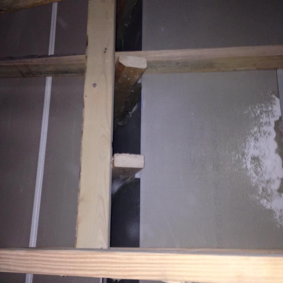 A wooden frame is sitting on top of a concrete floor.